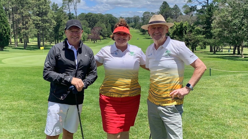 Meryl Swanson stands between Joel Fitzgibbon and Alex Gallacher on a golf course