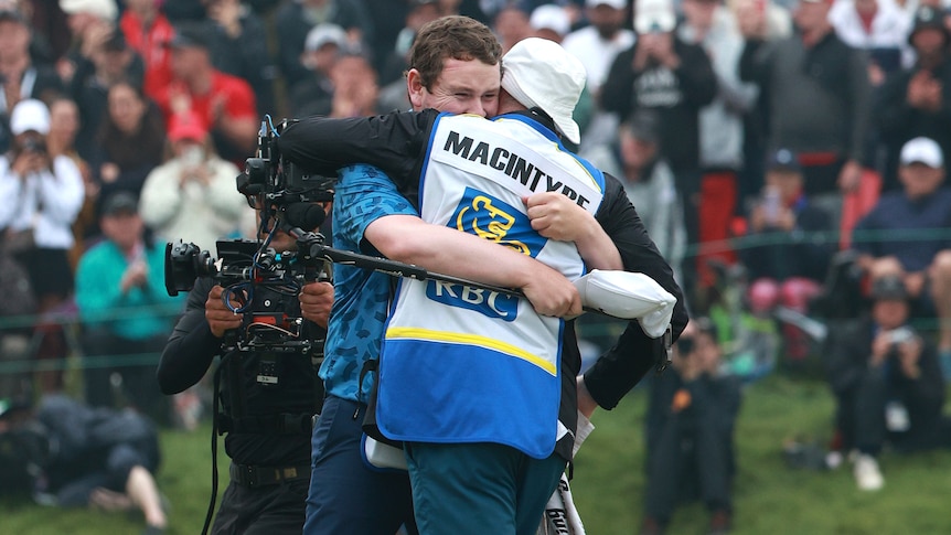 Golfer Robert MacIntyre hugs his father and caddy Dougie on the 18th green after winning the Canadian Open.