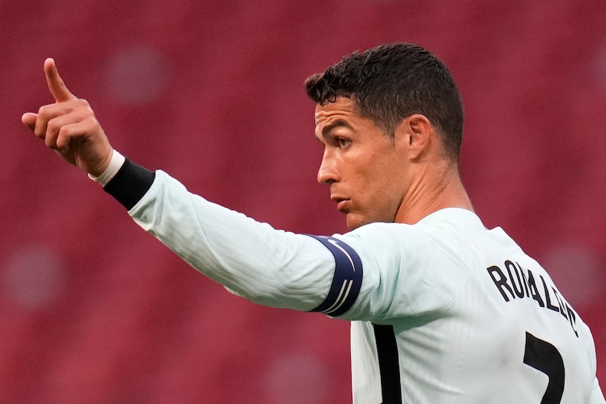 Cristiano Ronaldo gestures by pointing his finger in the sky