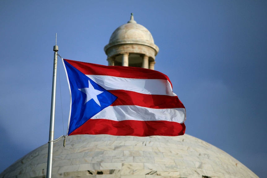 The Puerto Rican flag flies in front of Puerto Rico's Capitol