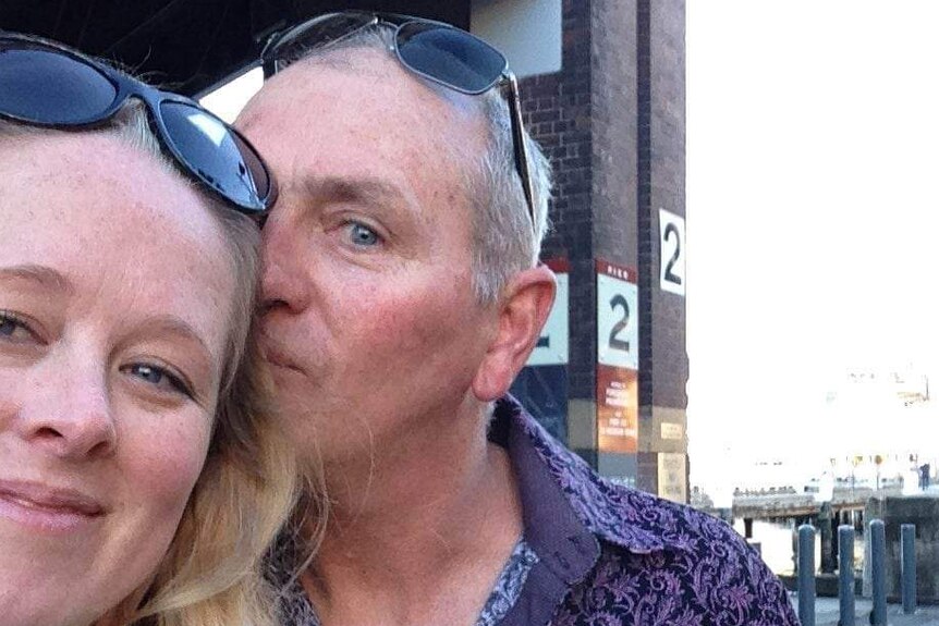 A social media selfie of a couple - he is kissing her cheek