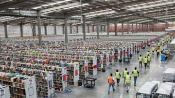 A factory with workers walking along an aisle