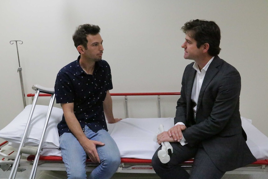 The pair discuss Reuben's progress on a hospital bed
