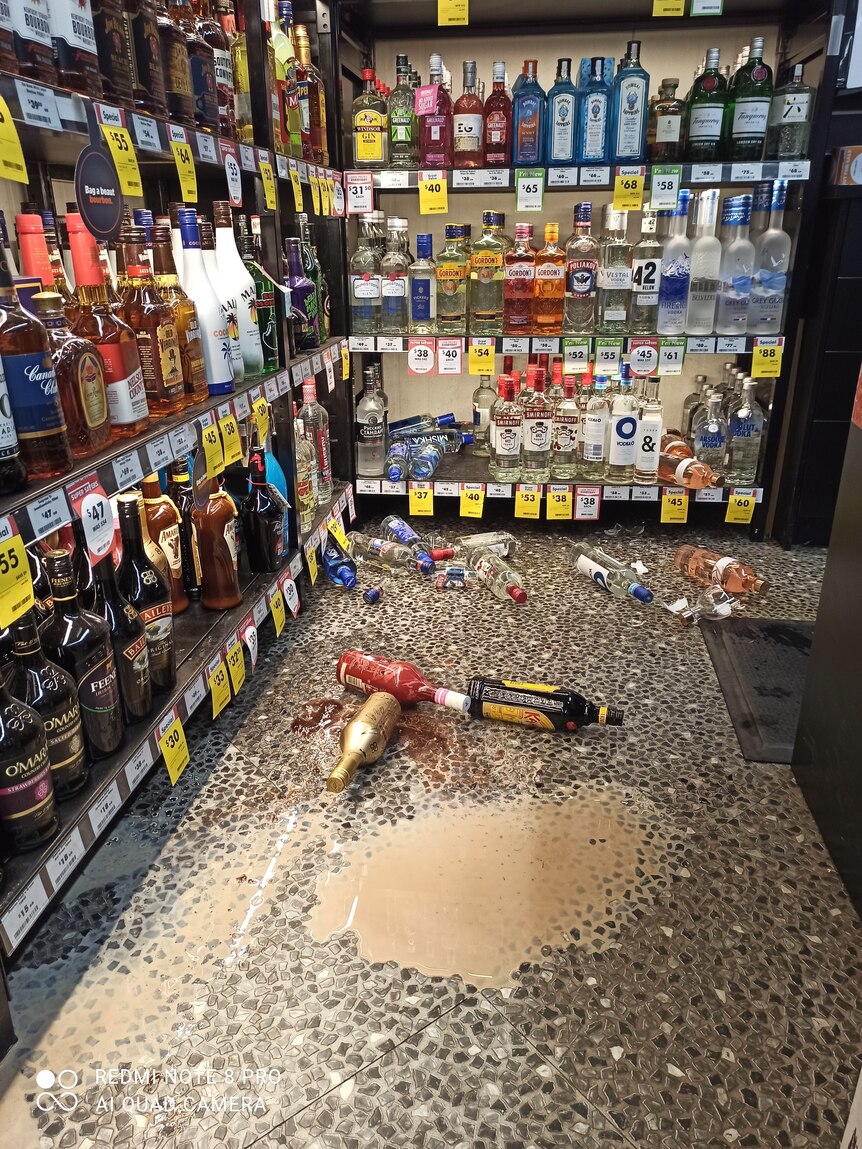 Broken alcohol bottles on the floor of bottle shop