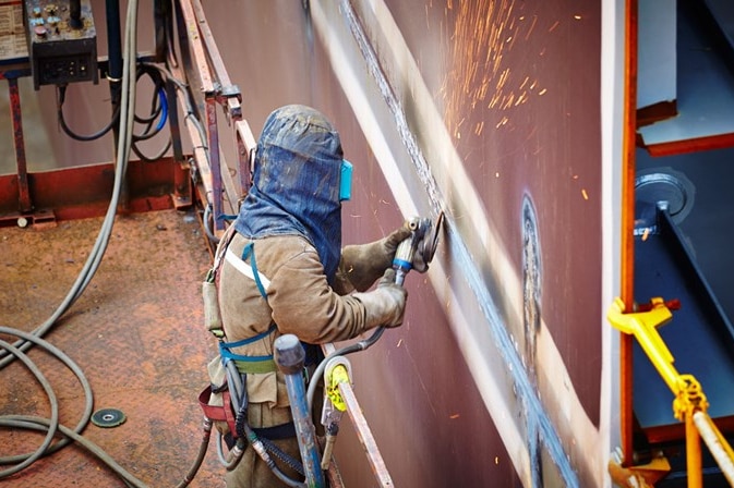 Worker using powertool at Inpex Ichthys LNG project.