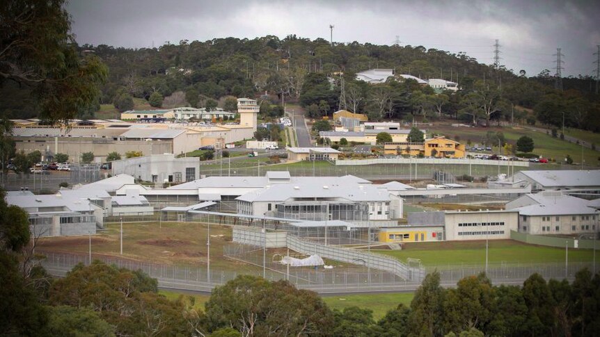 A prison complex with a hill in the background.
