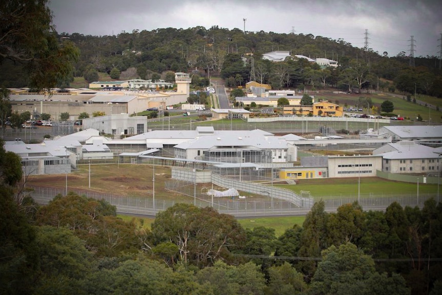 A prison complex with a hill in the background.