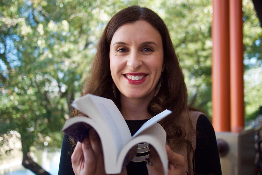 Randa Abdel-Fattah flicks through a copy of her latest book, When Michael Met Mina.