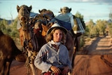 Writer Robyn Davidson is photographed with her camels and dog Diggity for National Geographic in 1977 in outback Australia.
