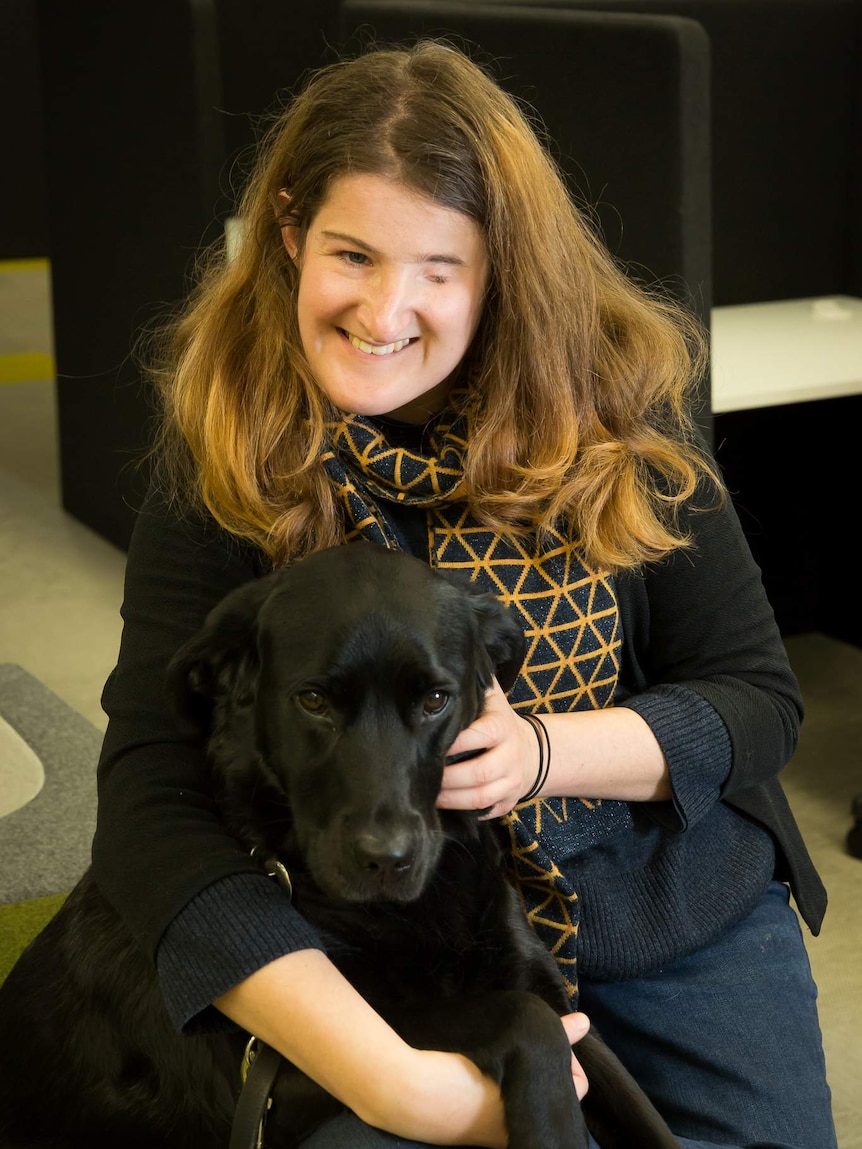 Writer Ellen Fraser-Barbour pats her guide dog, Inka