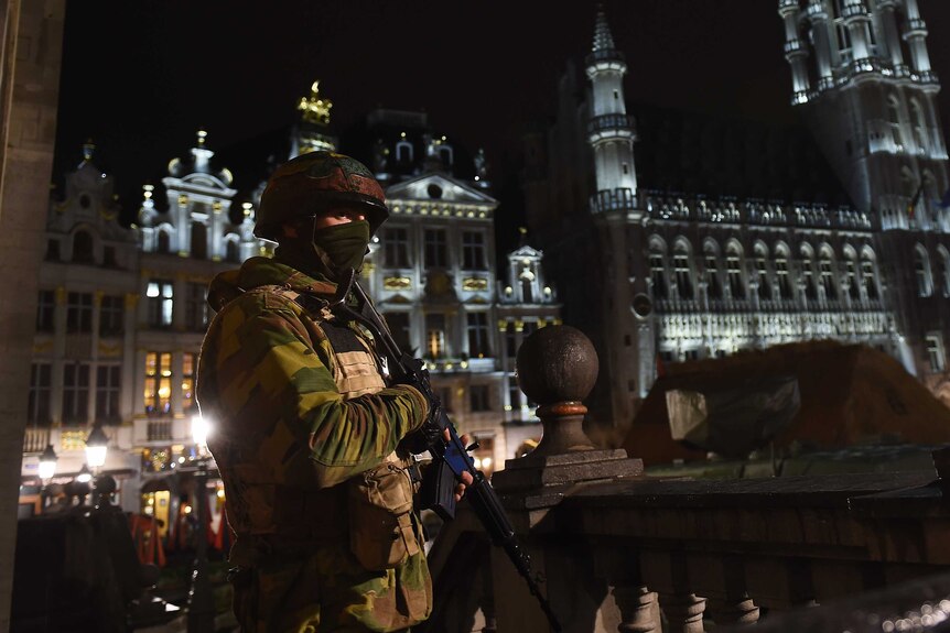 A Belgian soldier stands guard as a police intervention takes place around the Grand Place, Brussels