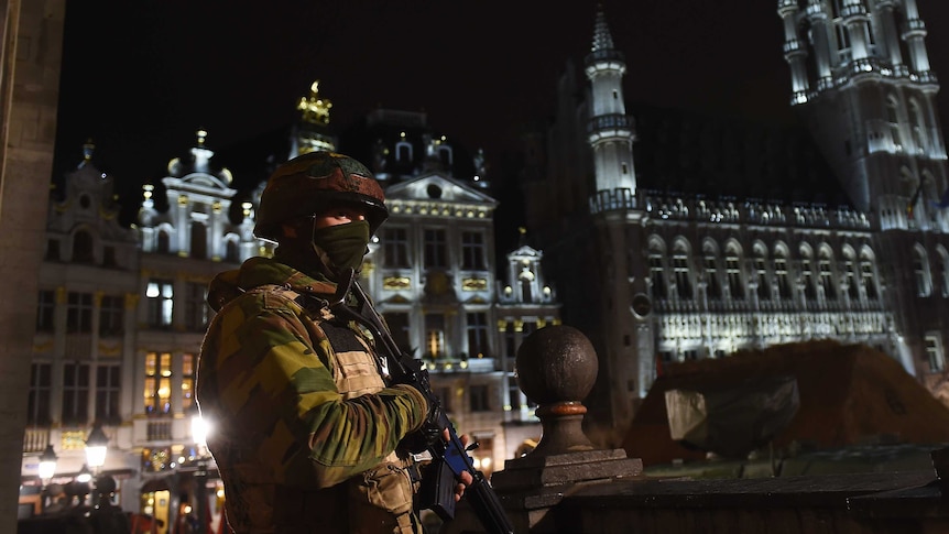 A Belgian soldier stands guard as a police intervention takes place around the Grand Place, Brussels