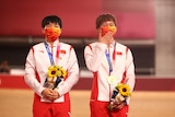 Gold medallists Bao Shanju of China and Zhong Tianshi of China stand on the podium holding flowers