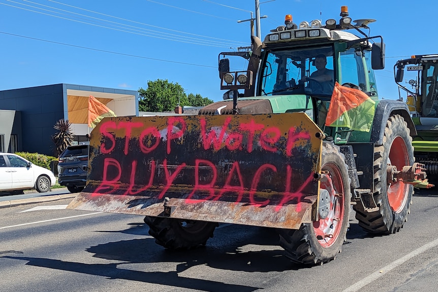 A tractor with "stop water buyback" painted on its front drives down Wyndham Street in Shepparton.