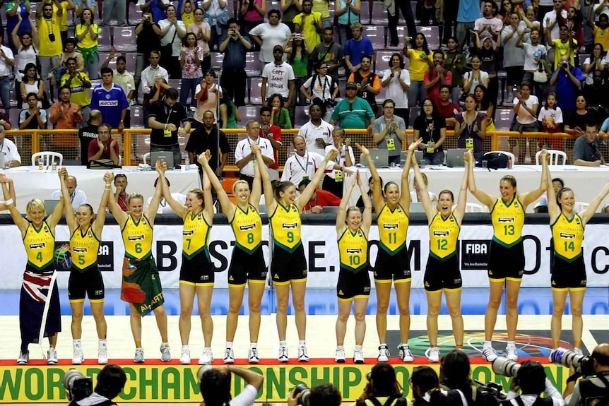 The Australian Opals basketball team stand on the podium raising their hands after winning the FIBA world championships in 2006.