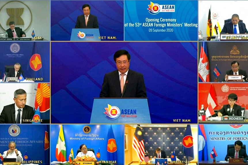 You view a split screen of various male foreign ministers around a large rectangle showing a man behind a lectern.