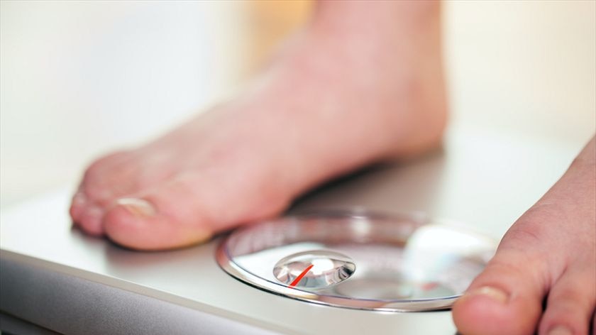 A close up of a pair of feet on a set of scales.