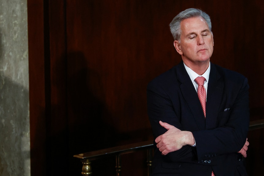 Kevin McCarthy closes his eyes and wraps his arms around himself