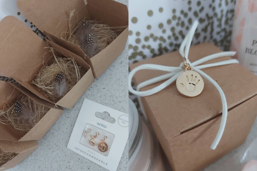 Small, square cardboard boxes with feathers, shredded paper inside, a little gold charm with a baby handprint.