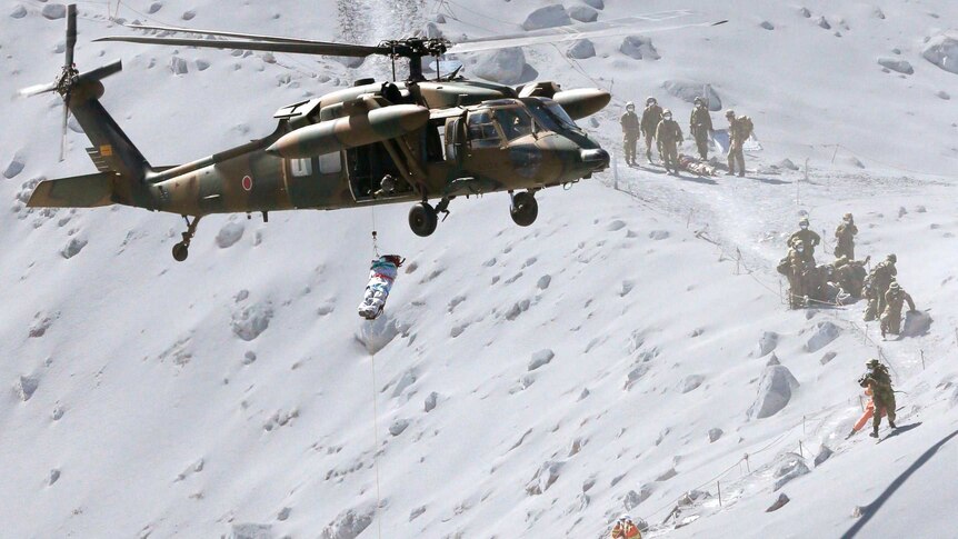 A hiker is lifted by rescue helicopter off Mount Ontake in Japan