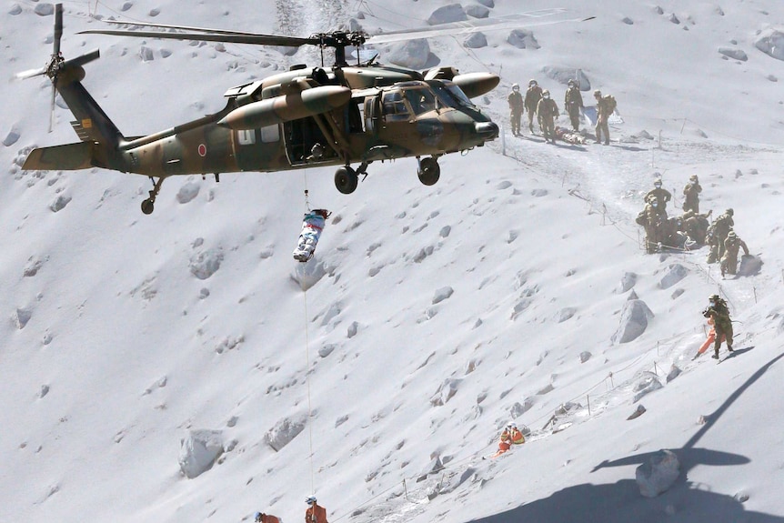 A hiker is lifted by rescue helicopter off Mount Ontake in Japan