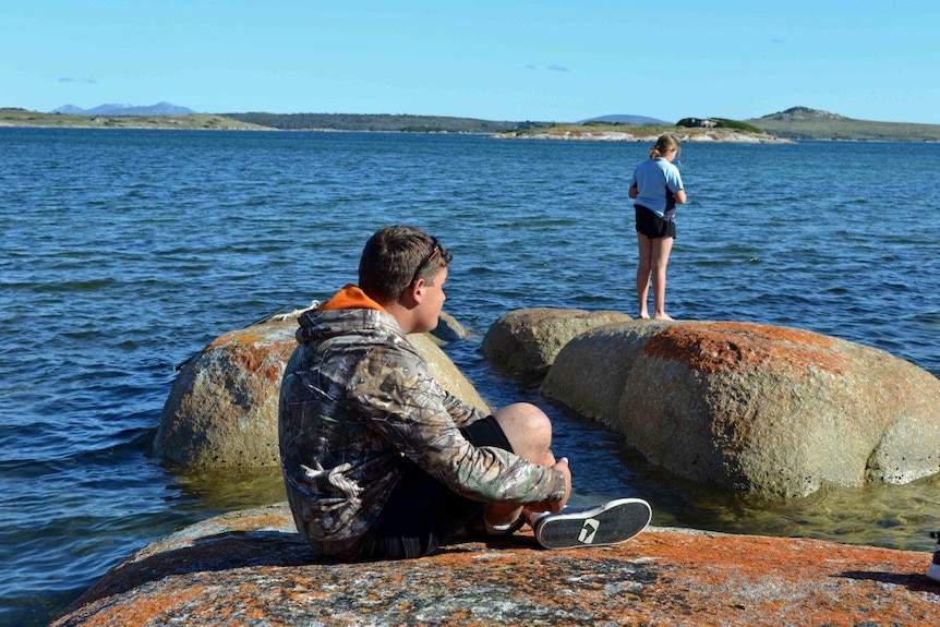 Teenagers Dylan Purdon and Emily Wood stand on rocks