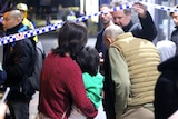 A group of people stand outside a building at night.