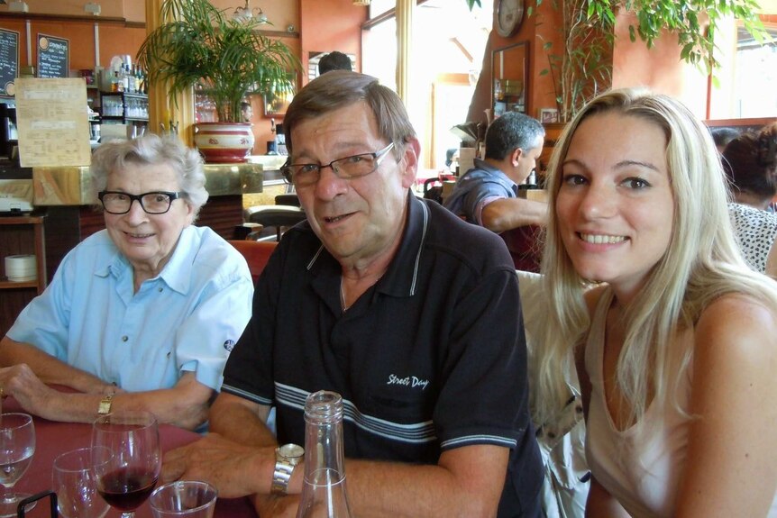 A woman at a restaurant with her father and grandmother