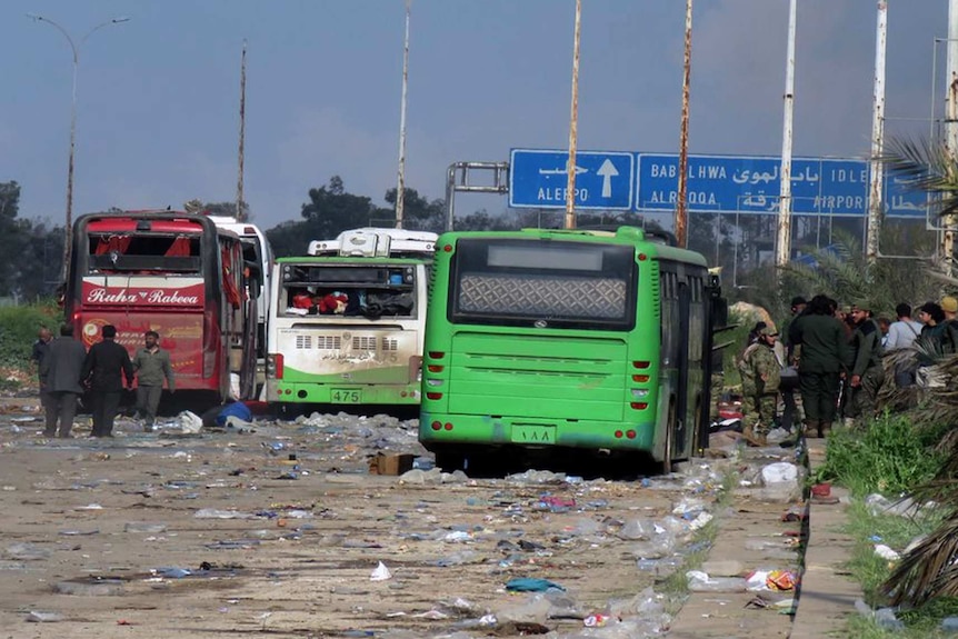 This image released by the Thiqa News Agency, shows buses at the evacuation point where an explosion hit at the Rashideen area, a rebel-controlled district outside Aleppo city