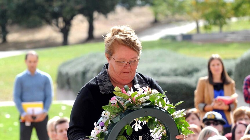 Veronica Croome lays a wreath at a ceremony honouring nurses and midwives