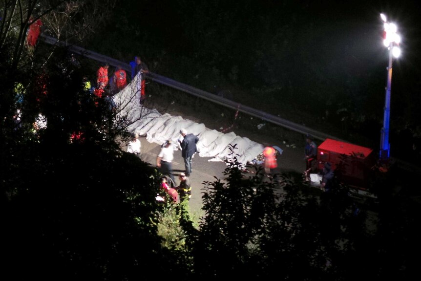 Rescuers line up the bodies of victims after a bus came off a flyover near Avellino, southern Italy.
