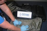 Customs officials at Sydney airport inspect a sports bag