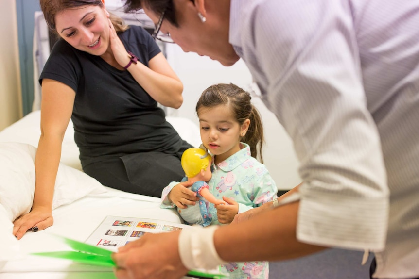 Melina and mum Armine choose a cartoon to watch with nurse Alice Lee.