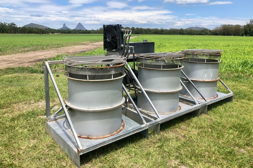 Three silver drums on the back of a frame that fits to a tractor.