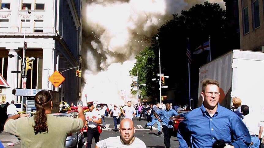 People run as one of the World Trade Centre towers collapses