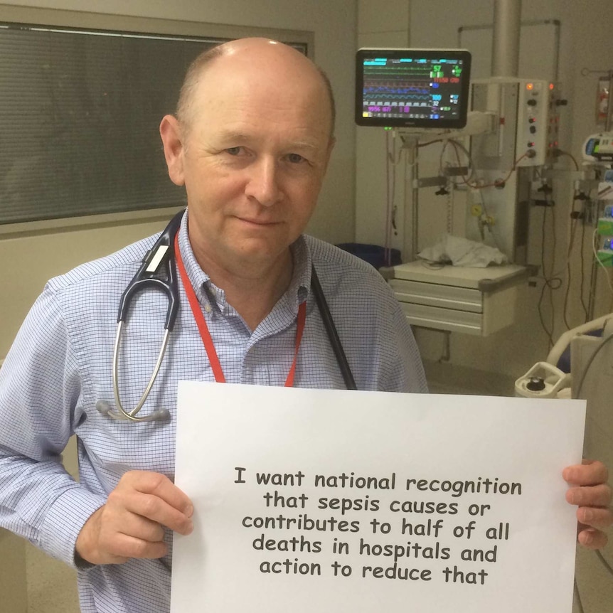 Prof. Simon Finfer holding up a sign campaigning for action on sepsis