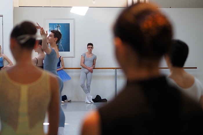 A male ballet dancer waiting to practice in the studio.