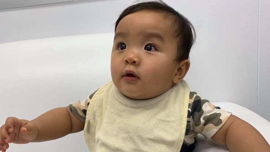 a baby in a bib looking up