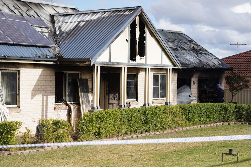 A cream-coloured house all but completely destroyed by fire.