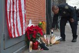 A police officer lays flowers at a makeshift memorial for two police officers shot dead in New York City