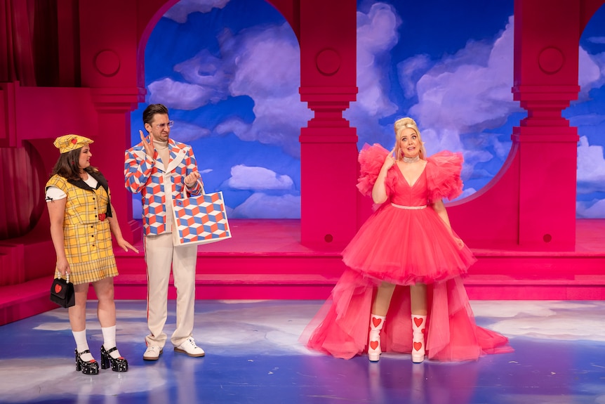 Melissa Kahraman and Aaron Tsindos look with disdain at Contessa Treffone, dressed in pink, on stage.