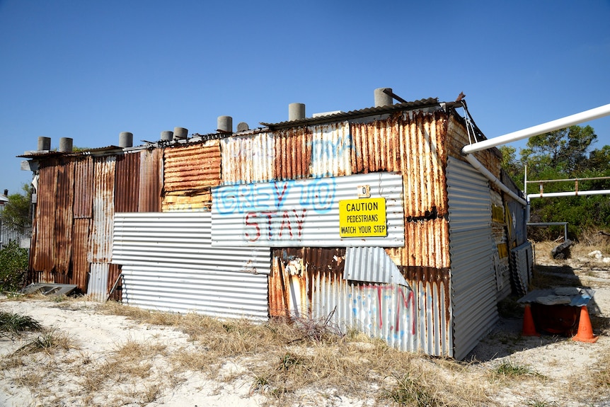 A rusty old shack made from corrugated iron right on the sand