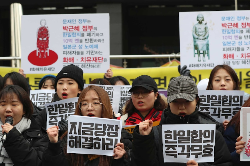 South Korean students shout slogans and hold up Korean posters that read "Immediately nullity, the agreement".