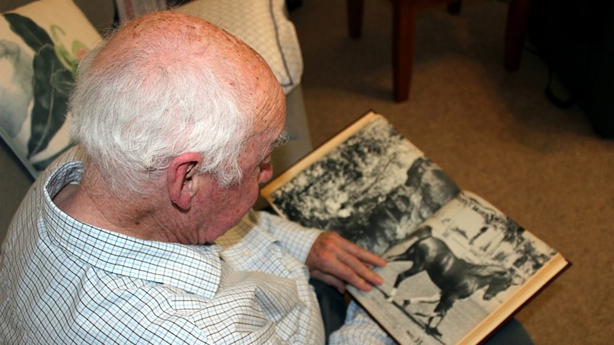 Pat Gallagher looks at a horse magazine.
