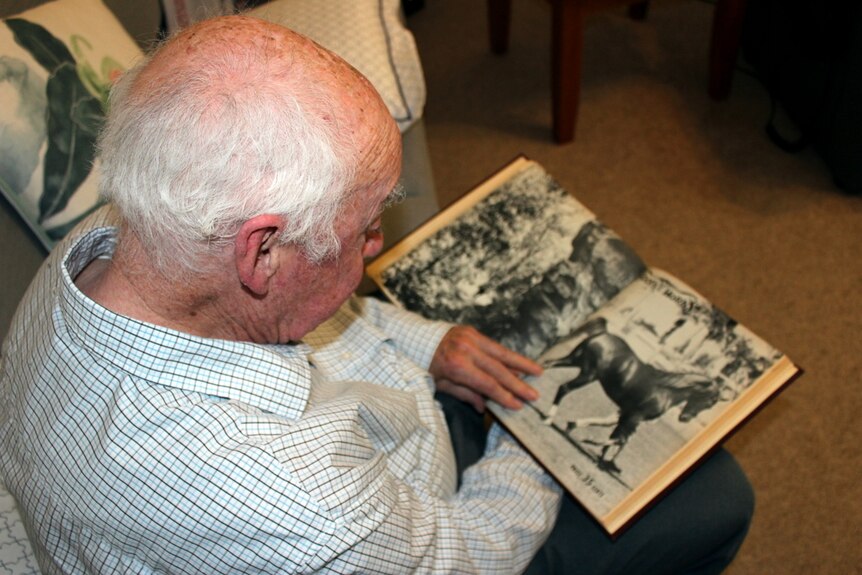 Pat Gallagher looks at a horse magazine.