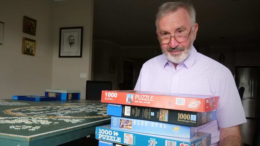 John Philpot holds some of his puzzle collection