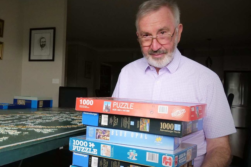 John Philpot holds some of his puzzle collection