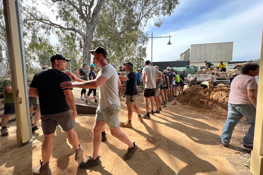 A line of volunteers filling sandbags.