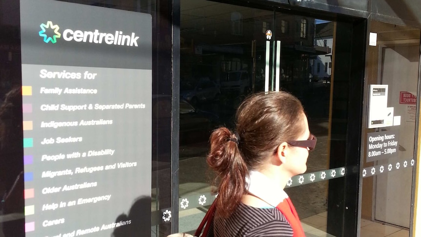 A woman walks past the Centrelink office