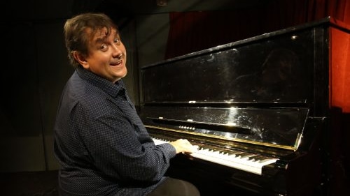 Pianist Ben Waters sitting at his piano